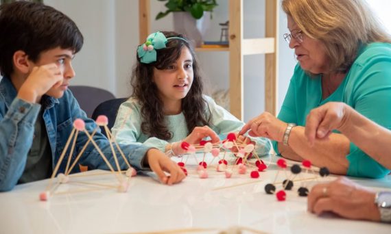 Grandmother playing educational games with grandchildren indoors, fostering creativity and learning.