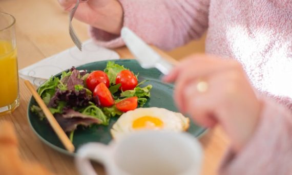 Enjoy a nutritious breakfast with greens, fried egg, and fresh orange juice for a healthy start to your day.